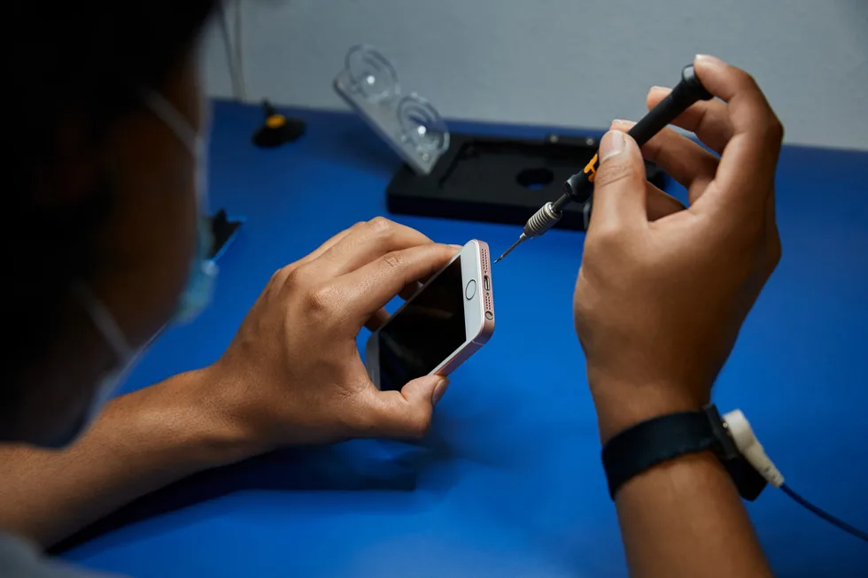 Technician inspecting a smartphone before an independent repair