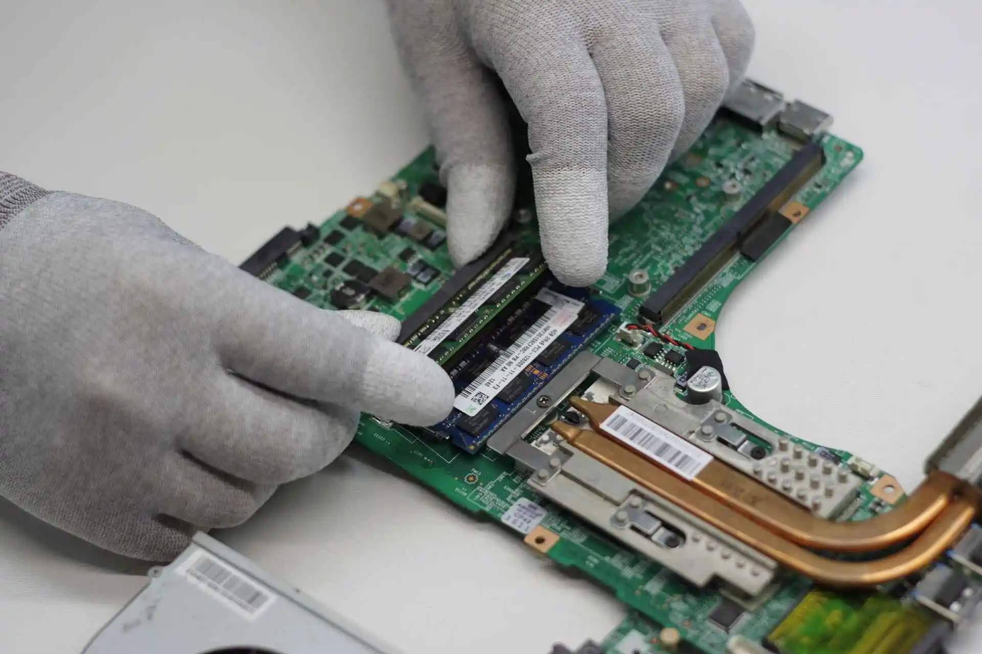 Student's laptop open on a desk during a repair check